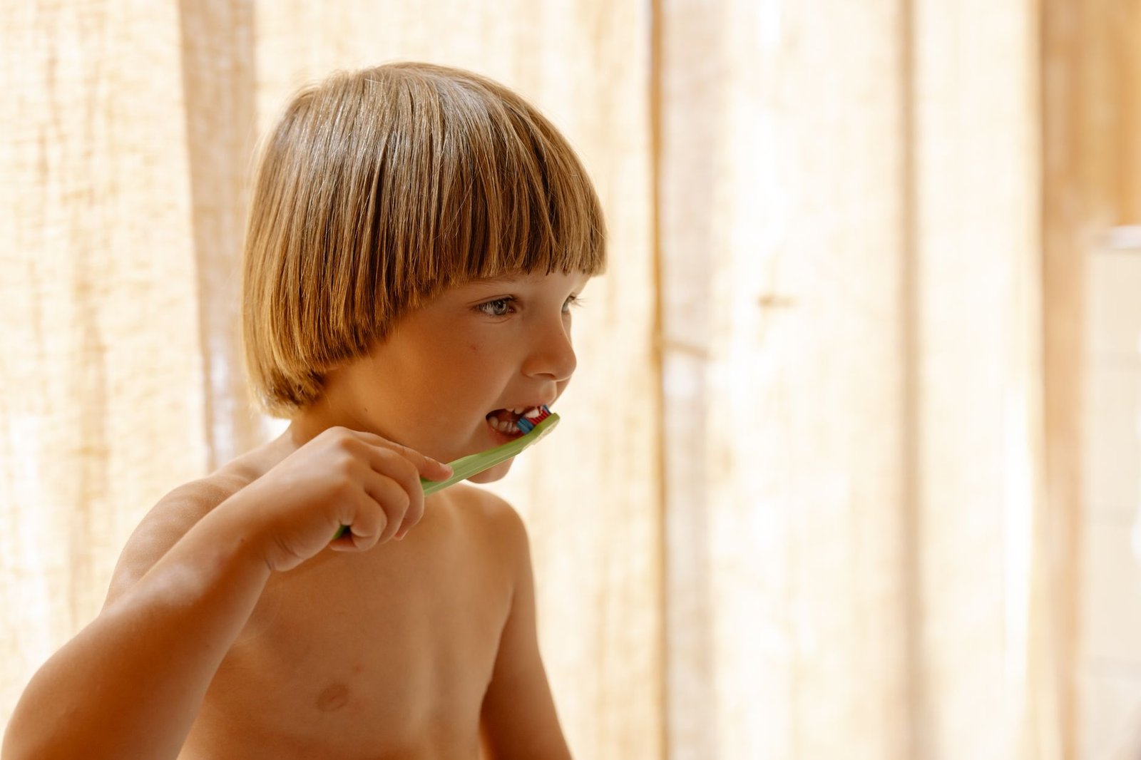 Niña cepillándose los dientes en el baño