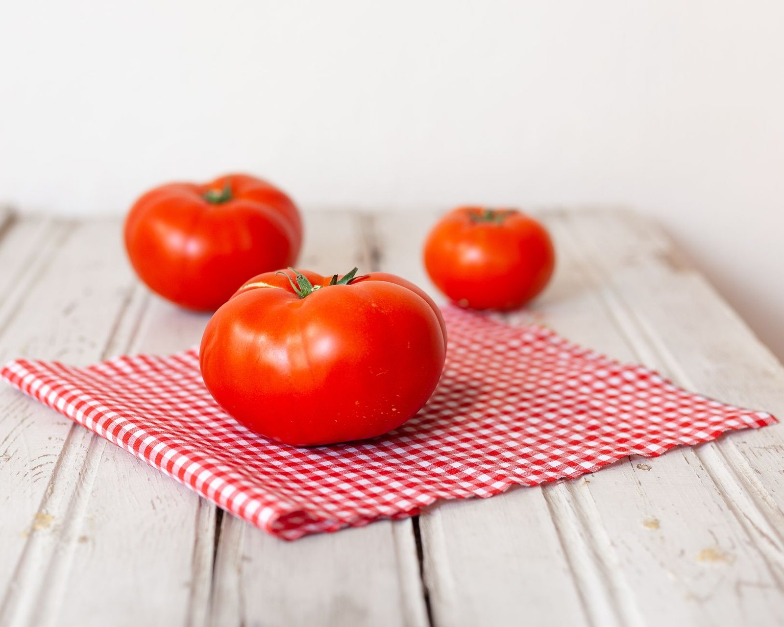Tomates maduros de distintos tipos sobre una mesa de madera