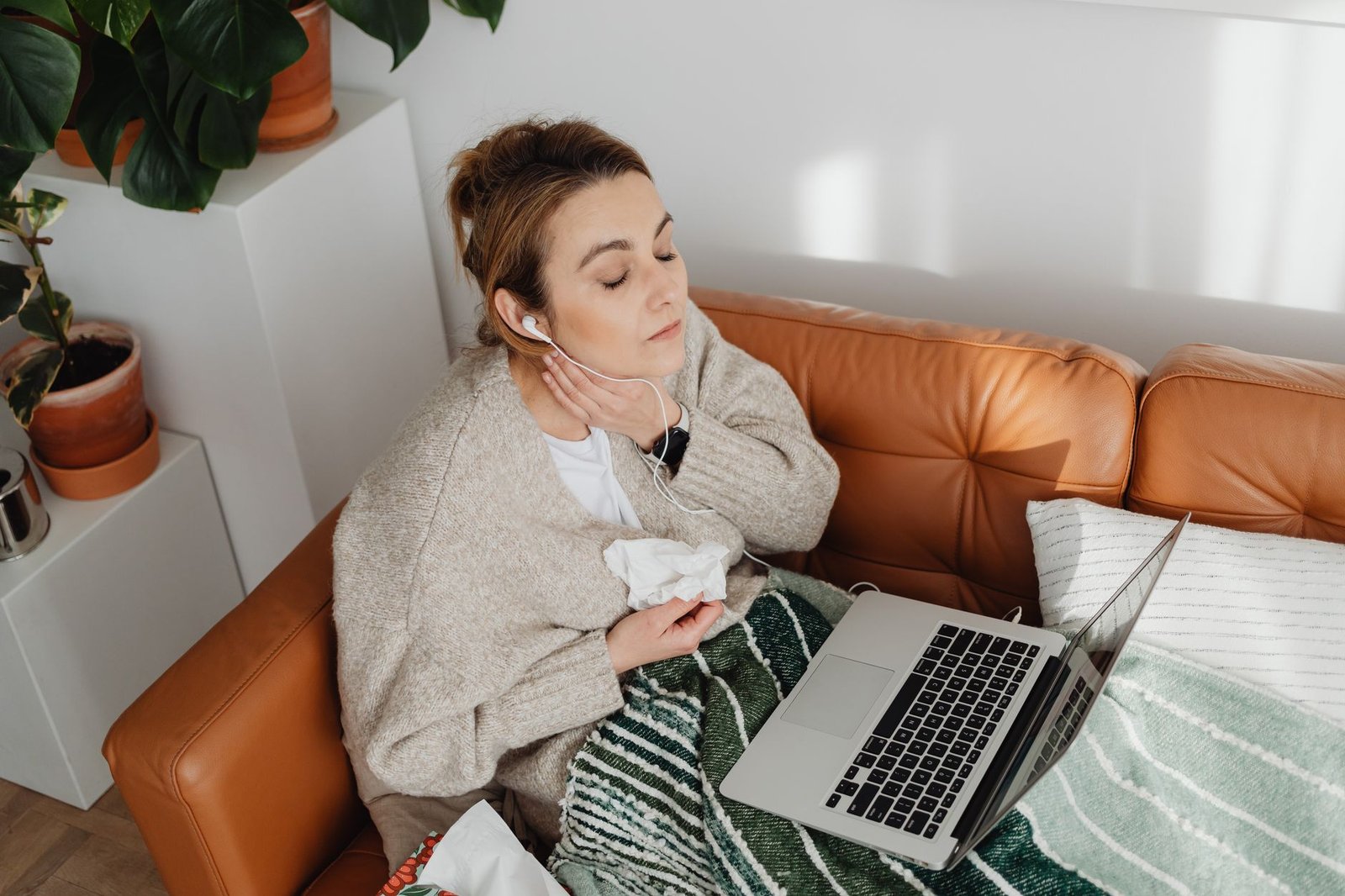 Mujer trabajando en su escritorio con una manta sobre los hombros