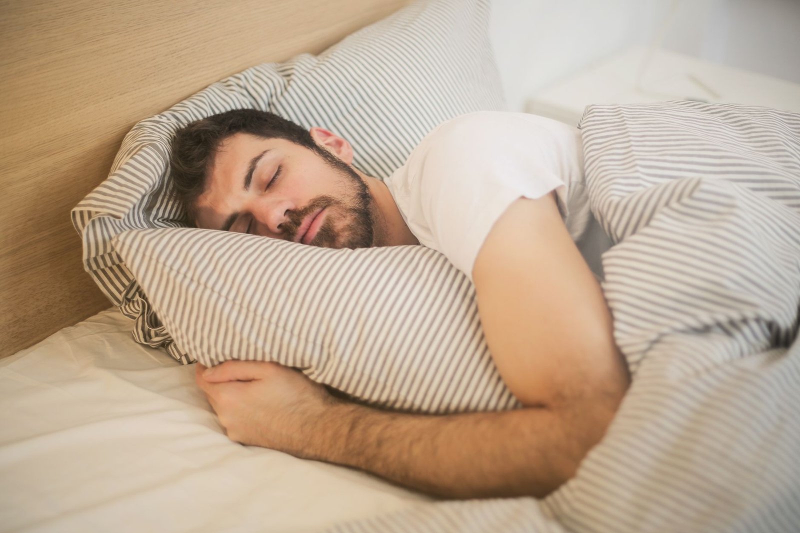 Hombre durmiendo boca arriba en la cama por la noche