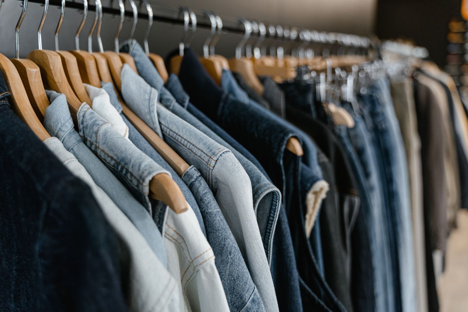 Varios vaqueros de hombre doblados y colgados en una tienda de ropa